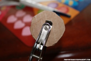 Use a hole punch to punch holes in the middle of the cardboard circle.