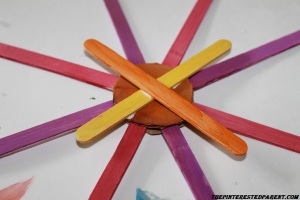 Glue 2 sticks in a X pattern over the top of the circle.
