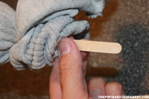 Stick a popsicle stick up the open end of the sock.