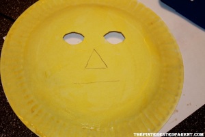 Draw your scarecrow face on the backside of the paper plate. Cut out the eyes. Paint your plate yellow. 